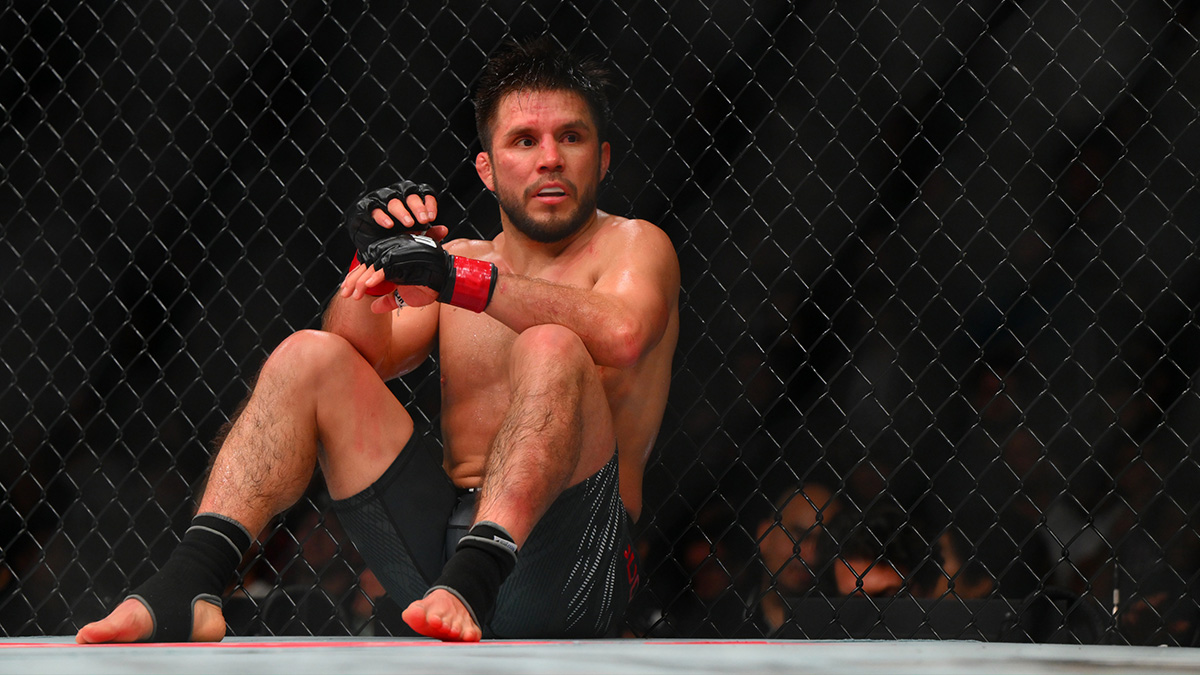 Henry Cejudo (red gloves) sits down after being poked in the eye by Song Yadong (blue gloves) in the bantamweight bout during UFC Fight Night at Climate Pledge Arena.