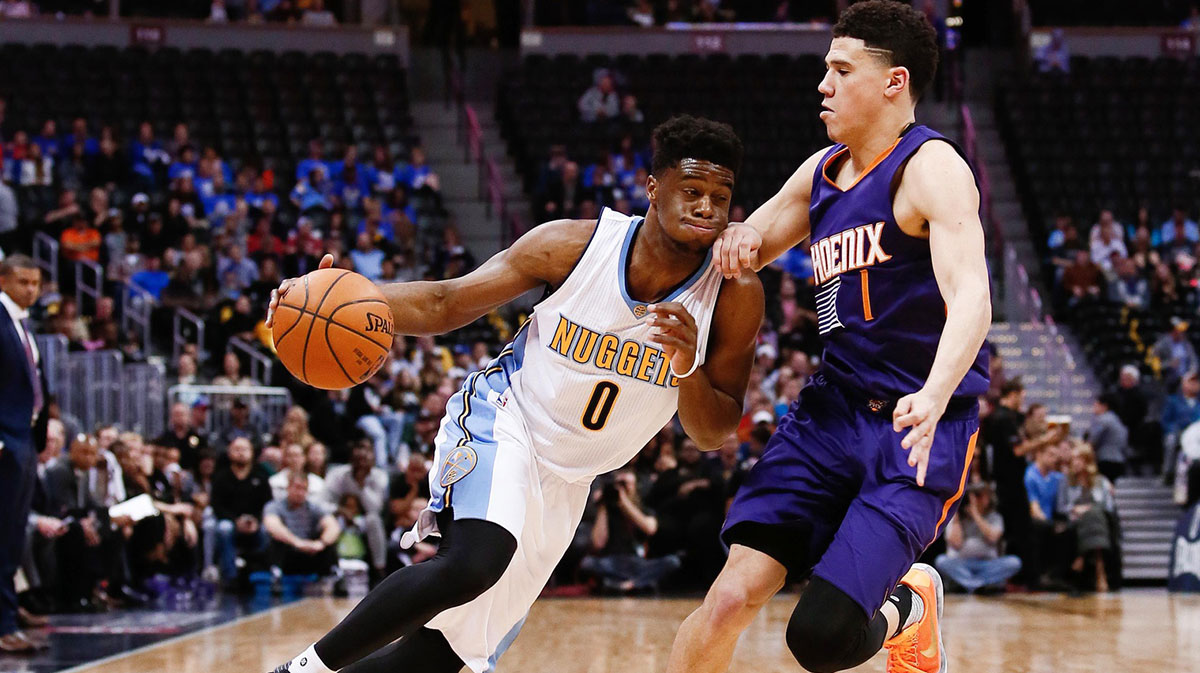 Phoenix Suns guard Devin Booker (1) guards Denver Nuggets guard Emmanuel Mudiay (0) in the second quarter at the Pepsi Center.