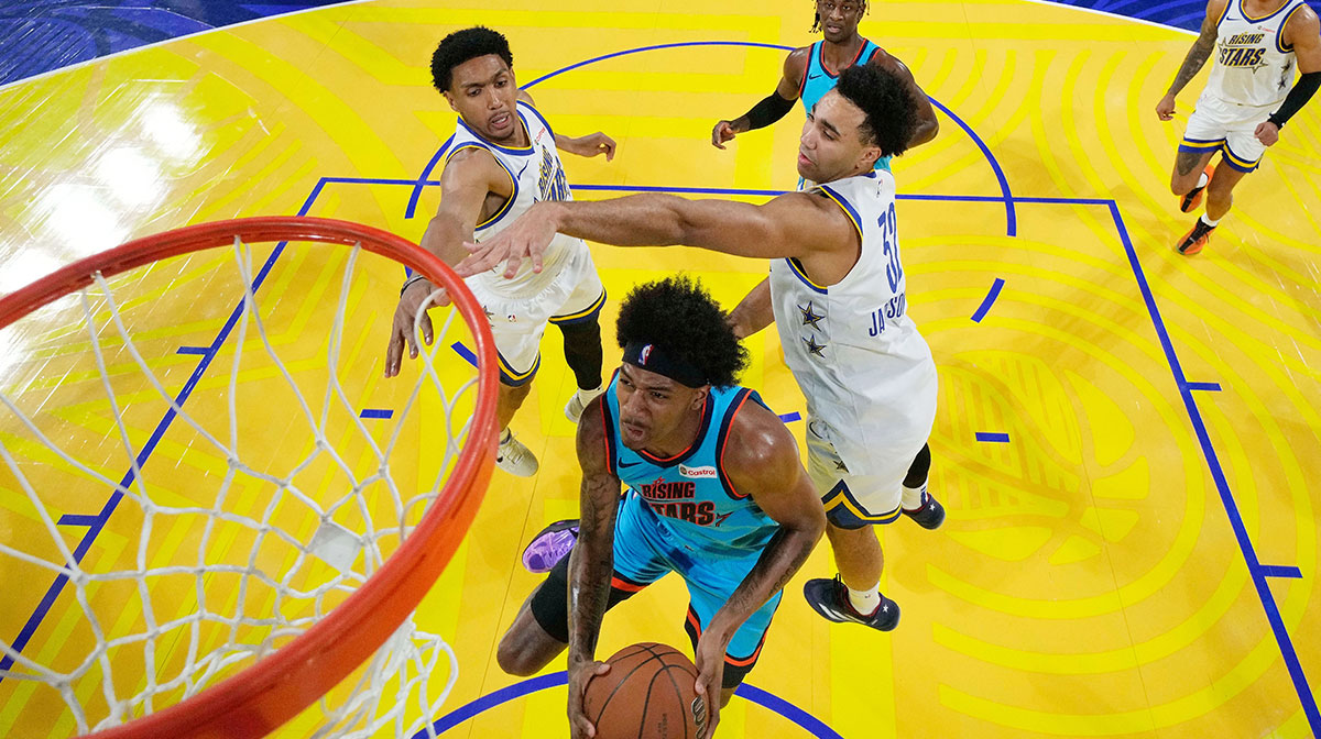 Team G-League guard Dink Pate (1) of the Mexico City Capitanes drives to the basket against Team C forward Ryan Dunn (0) of the Phoenix Suns and forward Trayce Jackson-Davis (32) of the Golden State Warriors during the 2025 NBA Rising Stars Game at Chase Center.