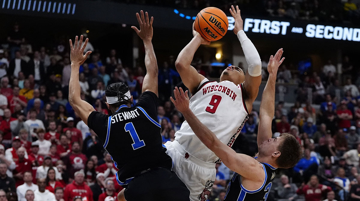Wisconsin Badgers guard John Tonje (9) shoots the ball over Brigham Young Cougars guard Trey Stewart (1) during the second half in the second round of the NCAA Tournament at Ball Arena.