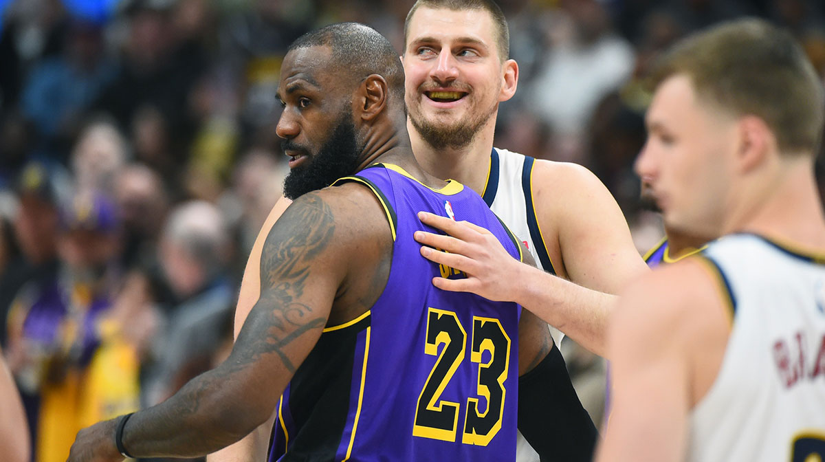Denver Nuggets center Nikola Jokic (15) and Los Angeles Lakers forward LeBron James (23) hug before the game at Ball Arena.