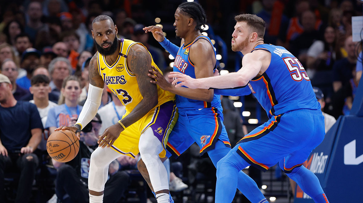 Los Angeles Lakers forward LeBron James (23) moves the ball as Oklahoma City Thunder forward Jalen Williams (8) and center Isaiah Hartenstein (55) defend the play during the second half at Paycom Center.