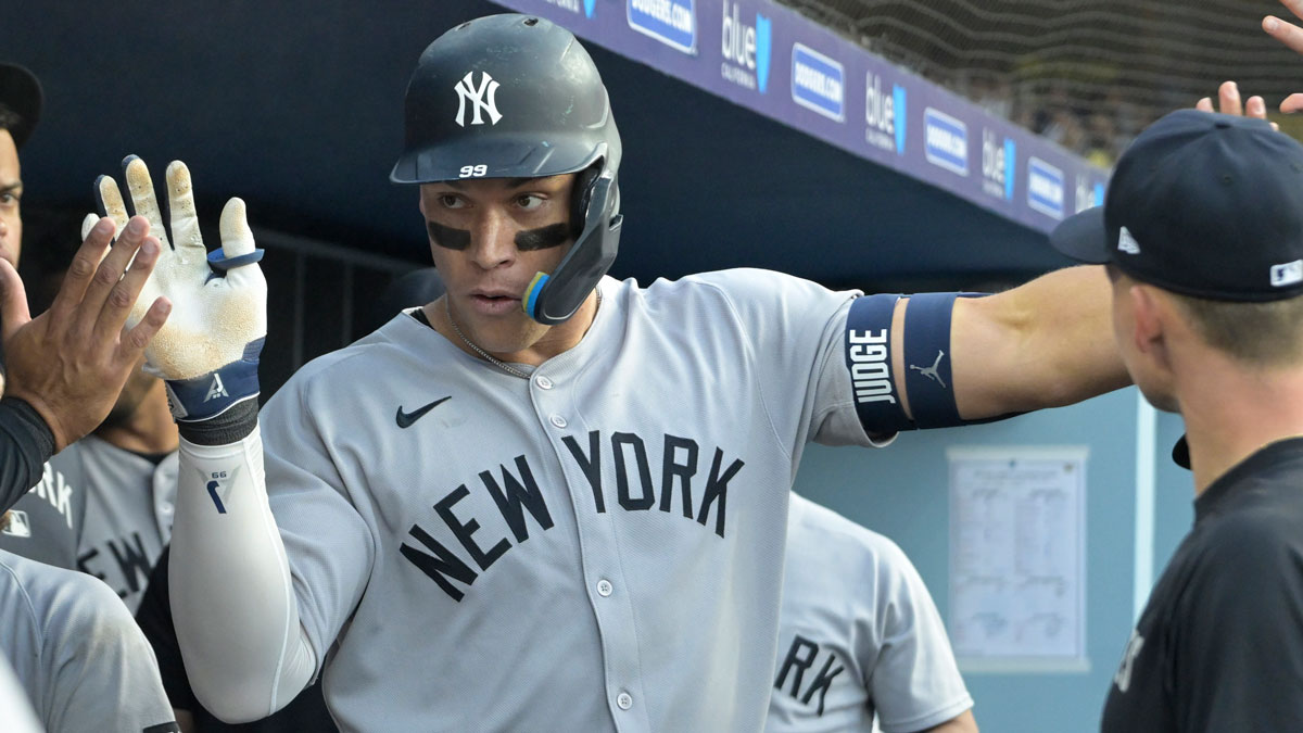 New York Yankees right fielder Aaron Judge (99) is congratulated in the dugout after hitting his second solo home run of the game in the eighth inning against the Los Angeles Dodgers at Dodger Stadium.