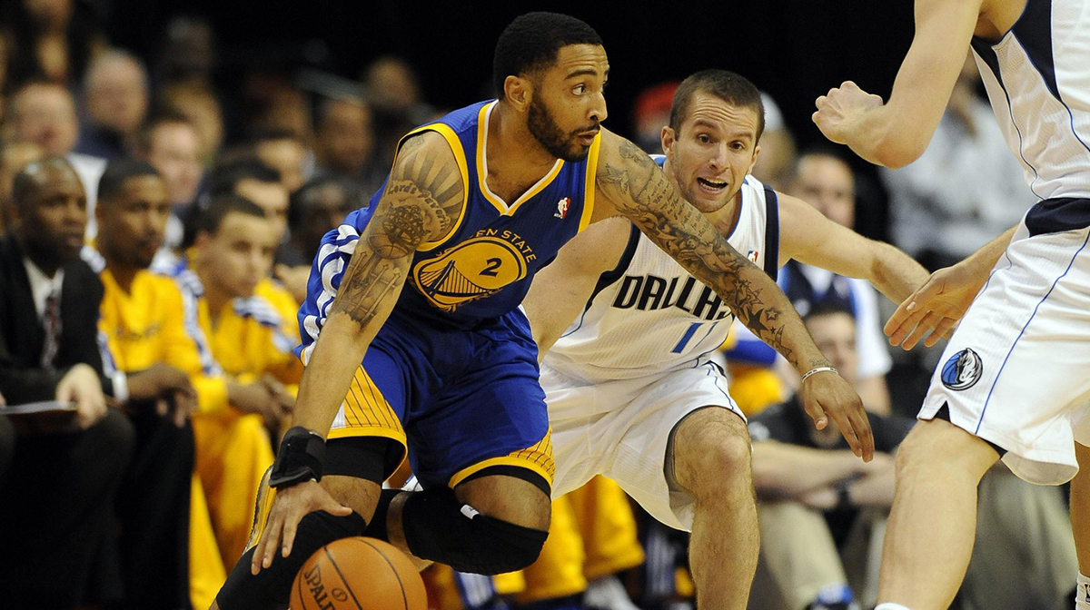 Golden State Warriors point guard Acie Law (2) drives the lane as Dallas Mavericks point guard Jose Juan Barea (11) defends during the first half at the American Airlines Center.