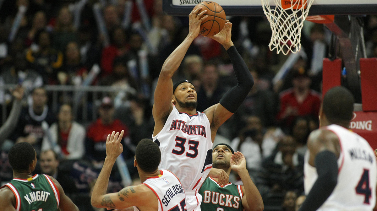 Atlanta Hawks forward Adreian Payne (33) grabs a rebound against the Milwaukee Bucks in the first quarter at Philips Arena.
