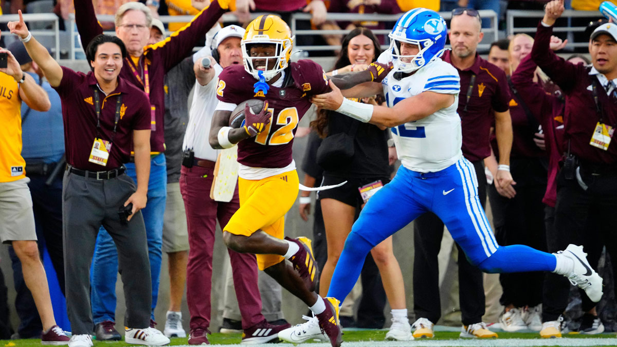 BYU quarterback Jake Retzlaff (12) tackles Arizona State defensive back Javan Robinson (12) as he returns an interception during the second half at Mountain America Stadium in Tempe.