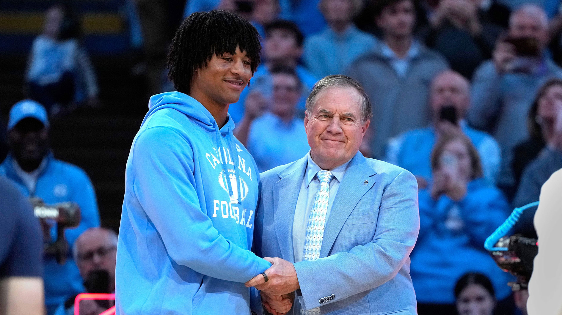 North Carolina Tar Heels head football coach Bill Belichick with recruit quarterback Bryce Baker during half time at Dean E. Smith Center.