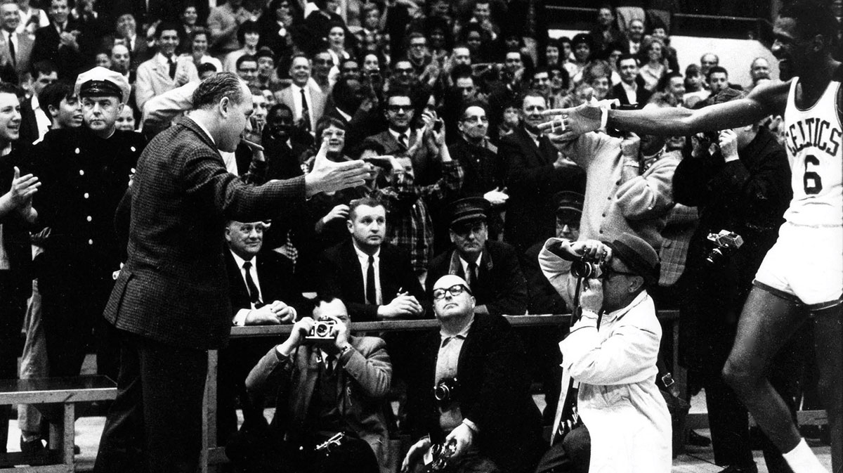 Boston Celtics former head coach Red Auerbach is congratulated after a game by former Celtics great Bill Russell at the Boston Garden in Boston, MA.