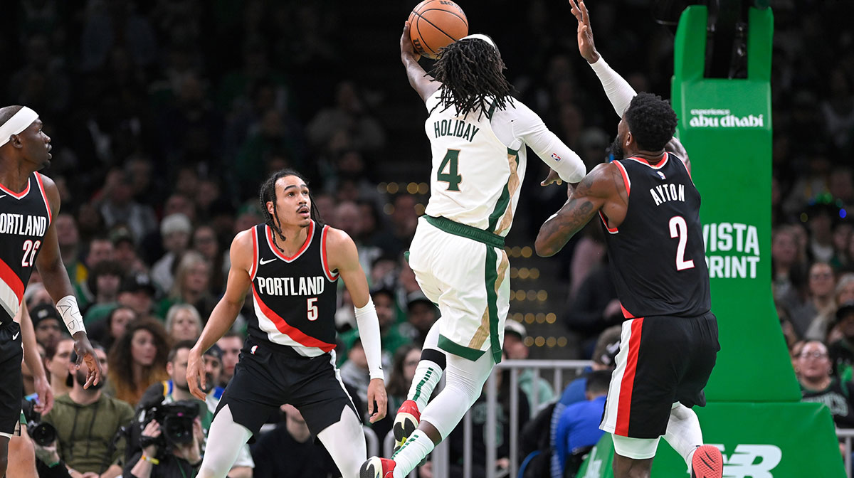 Boston Celtics guard Jrue Holiday (4) shoots the ball against Portland Trail Blazers center Deandre Ayton (2) during the first half at TD Garden.