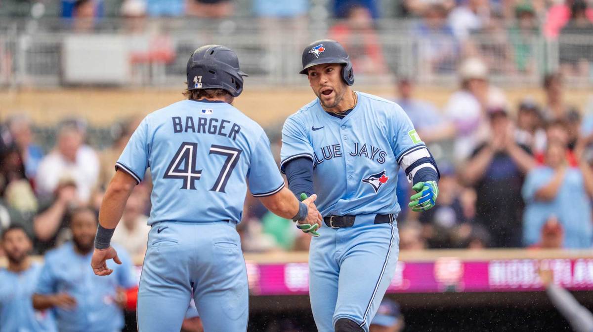 Toronto Blue Jays outfielder George Springer (4) crosses home plate after hitting a home run to score Toronto Blue Jays third base Addison Barger (47) off Minnesota Twins pitcher Griffin Jax (22) in the eithth inning at Target Field.