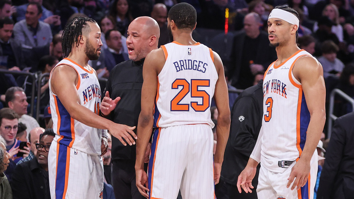New York Knicks assistant coach Rick Brunson talks with New York Knicks guard Jalen Brunson (11), forward Mikal Bridges (25), and guard Josh Hart (3) during a timeout in the third quarter against the Boston Celtics at Madison Square Garden.