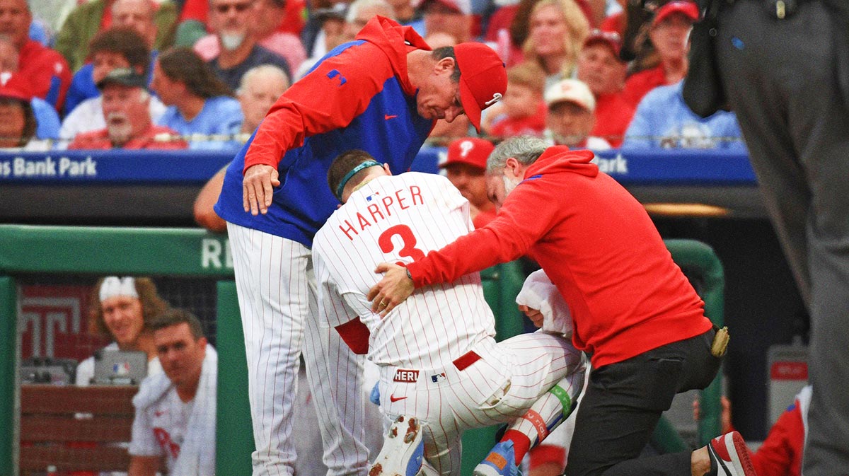 Philadelphia Phillies first base Bryce Harper (3) is looked at by Philadelphia Phillies manager Rob Thomson (59) and trainer Joe Rauch after being hit by a pitch during the first inning.