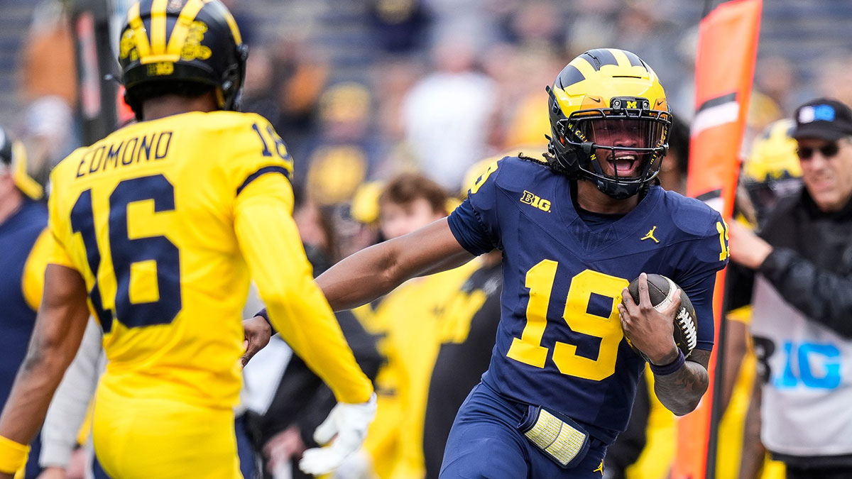 Team Blue quarterback Bryce Underwood (19) runs against Team Maize defensive back Jo'Ziah Edmond (16) during the second half of the spring game at Michigan Stadium