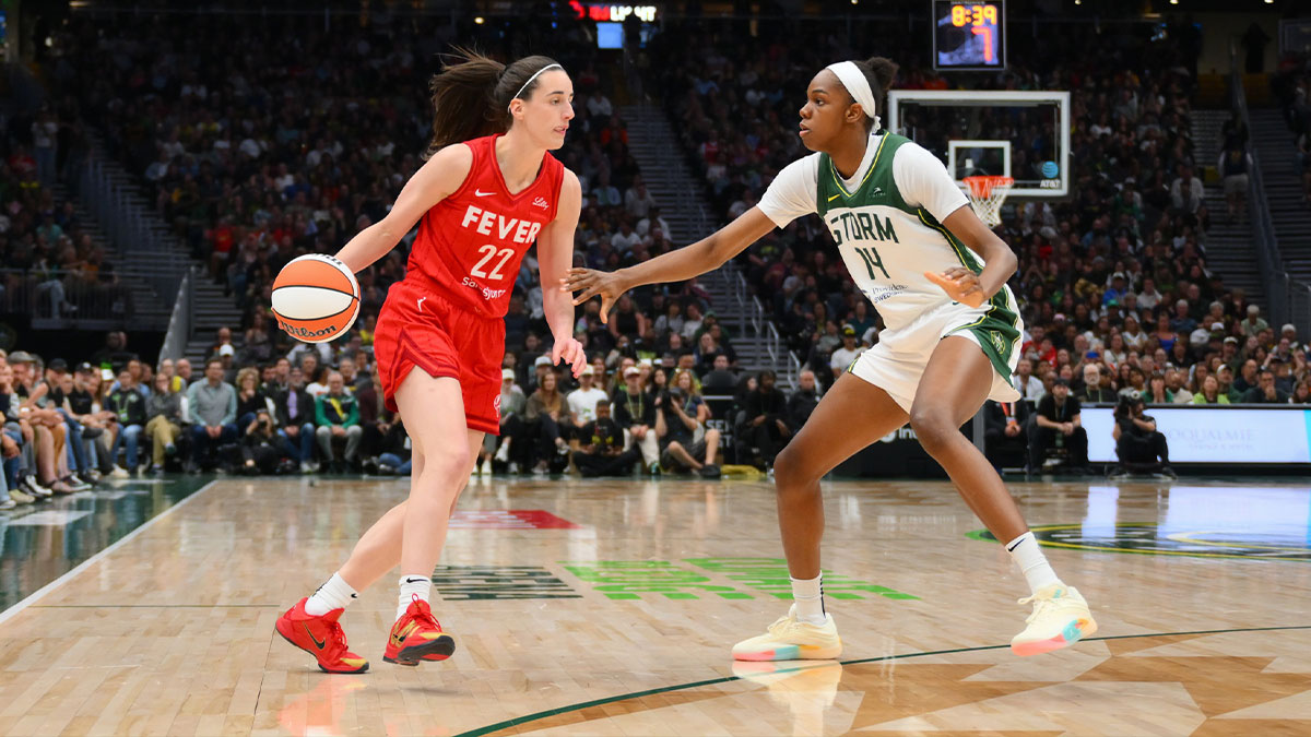 Indiana Fever guard Caitlin Clark (22) dribbles the ball while guarded by Seattle Storm center Dominique Malonga (14) during the second half at Climate Pledge Arena.