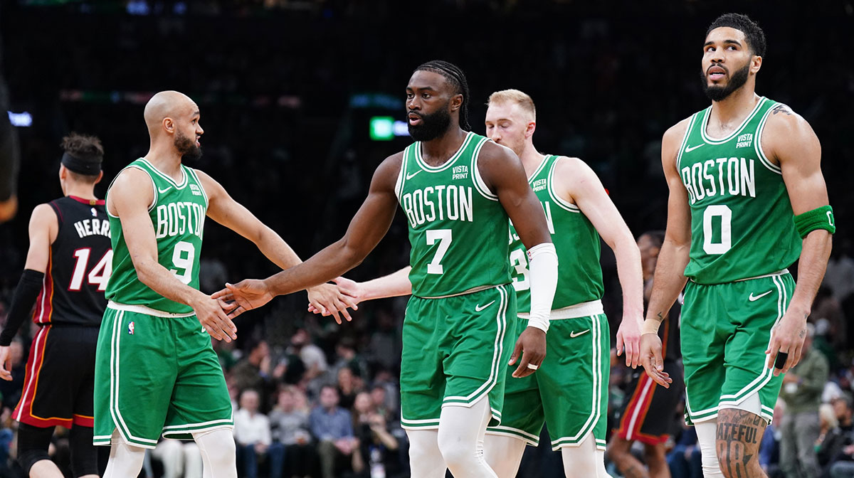 Celtics guard Jaylen Brown (7), forward Jayson Tatum (0), guard Derrick White (9) and forward Sam Hauser (30) walk to the bench during a timeout against the Miami Heat in the second quarter during game two of the first round for the 2024 NBA playoffs at TD Garden