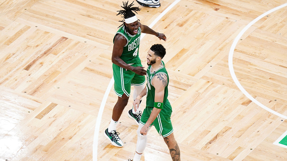 Boston Celtics forward Jayson Tatum (0) reacts with guard Jrue Holiday (4) in the fourth quarter against the Dallas Mavericks during game five of the 2024 NBA Finals at TD Garden.