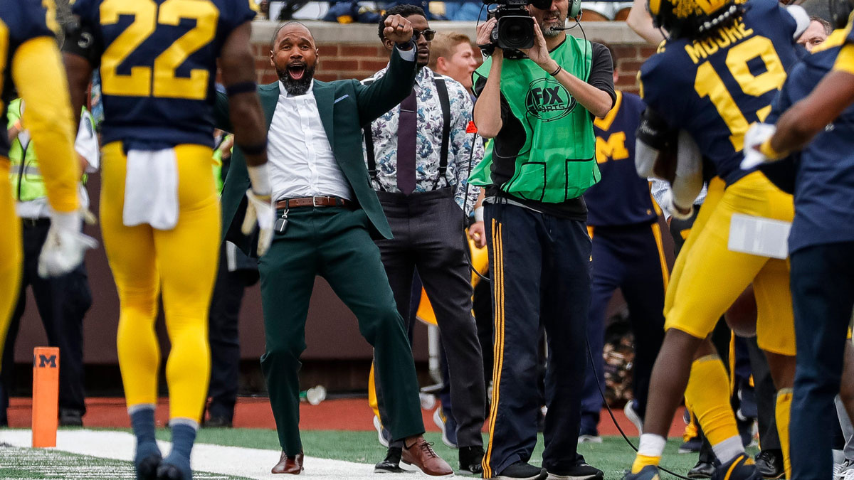 Charles Woodson, center, celebrates an interception made by Michigan defensive back R.J. Moten (6) against Maryland during the second half at the Michigan Stadium