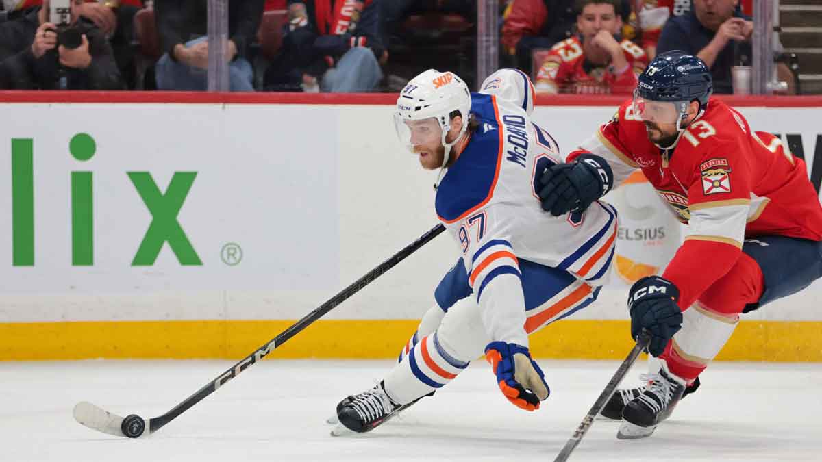 Edmonton Oilers center Connor McDavid (97) controls the puck defended by Florida Panthers center Sam Reinhart (13) during the first period in game six of the 2025 Stanley Cup Final at Amerant Bank Arena.