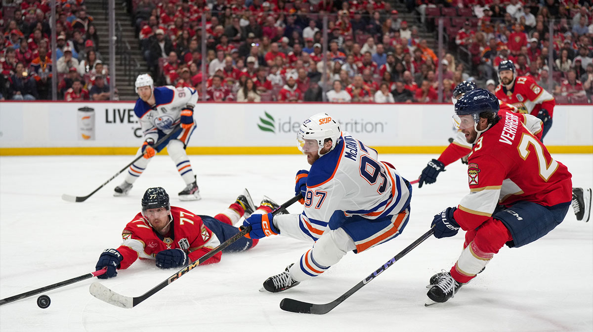 Florida Panthers defenseman Niko Mikkola (77) deflects the puck against Edmonton Oilers center Connor McDavid (97) during the third period in game six of the 2025 Stanley Cup Final at Amerant Bank Arena.