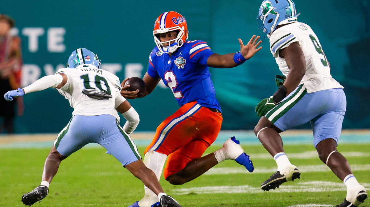 Florida Gators quarterback DJ Lagway (2) eludes Tulane Green Wave defensive back Lu Tillery (10) and Tulane Green Wave linebacker Terrell Allen (9) during the second half at Raymond James Stadium in Tampa, FL on Friday, December 20, 2024 in the 2024 Union Home Mortgage Gasparilla Bowl. The Gators defeated Tulane 33-8.