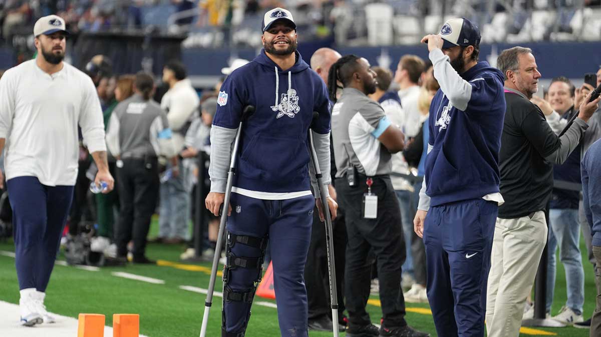 Dallas Cowboys quarterback Dak Prescott (left) stands on crutches before the game against the New York Giants at AT&T Stadium.