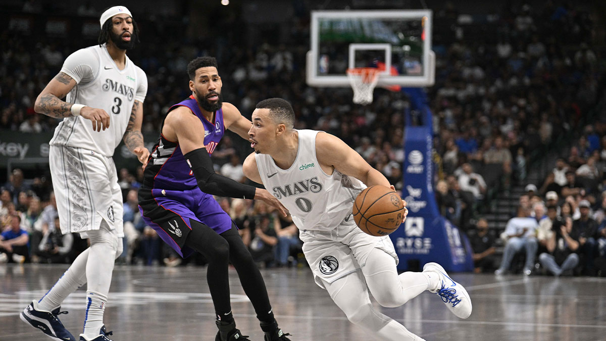 Dallas Mavericks guard Dante Exum (0) drives to the basket past forward Anthony Davis (3) and Toronto Raptors forward Garrett Temple (17) during the second half at the American Airlines Center.