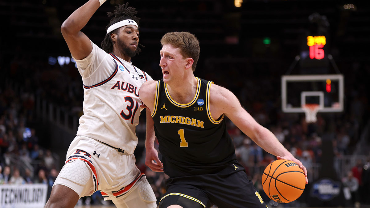 Michigan Wolverines center Danny Wolf (1) drives against Auburn Tigers forward Chaney Johnson (31) in the second half of a South Regional semifinal of the 2025 NCAA tournament at State Farm Arena.