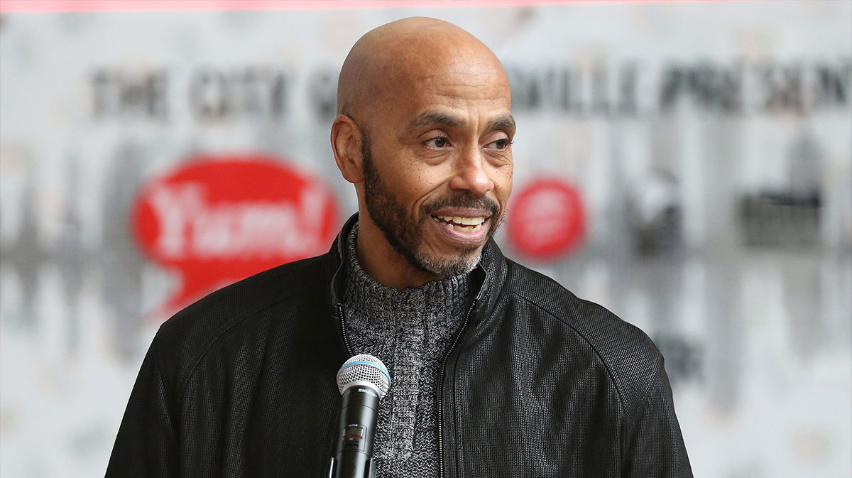 Former UofL great Darrell Griffith speaks during a ceremony to honor former head coach Denny Crum. A banner honoring Crum was installed on the side of Whiskey Row Lofts on Sunday, March 12, 2023. Crum was one of the original honorees from the 20-year old program whose banner had been removed at it's previous location due to construction. It now hangs across from the KFC Yum! Center.