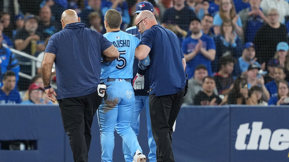 May 31, 2025; Toronto, Ontario, CAN; Toronto Blue Jays centre fielder Daulton Varsho (5) is helped off the field after grabbing his left leg after rounding second base against the Athletics during the third inning at Rogers Centre.