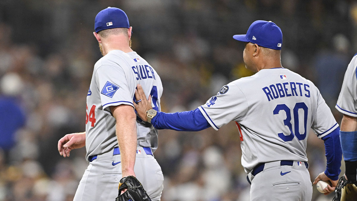 Los Angeles Dodgers manger Dave Roberts helps Matt Sauer (64) off the field during the sixth inning against the San Diego Padres at Petco Park.
