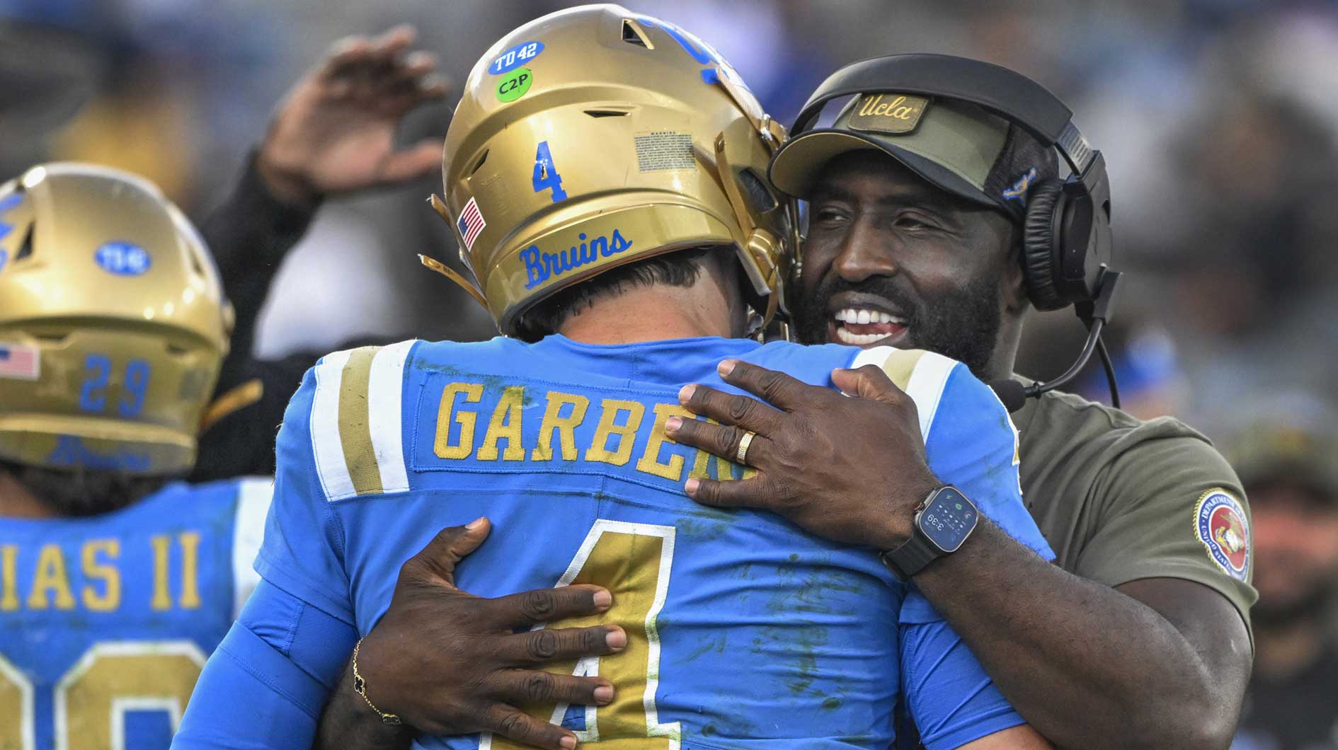 UCLA Bruins head coach DeShaun Foster hugs quarterback Ethan Garbers (4) as time runs out during a Bruins victory over the Fresno State Bulldogs at Rose Bowl.