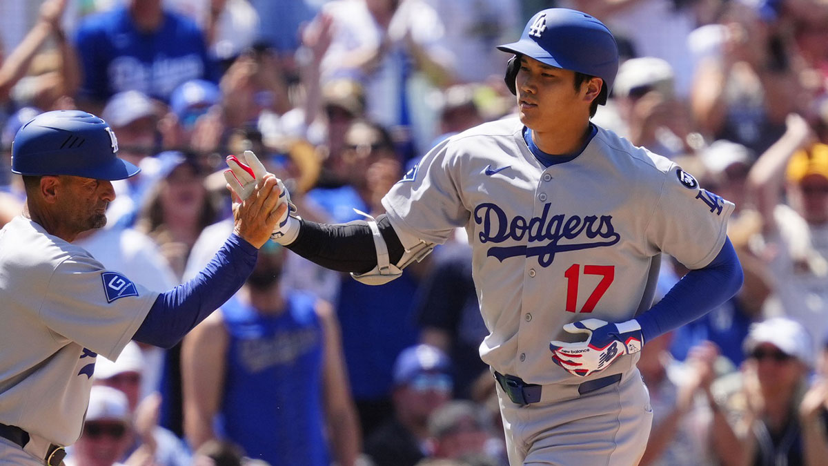 Los Angeles Dodgers third base coach Dino Ebel (91) congratulates Los Angeles Dodgers designated hitter Shohei Ohtani (17) after his solo home run in the seventh inning at Coors Field. Cameron Muncy
