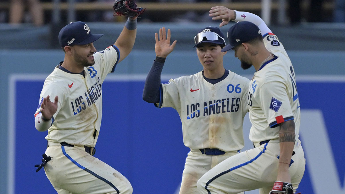 Los Angeles Dodgers left fielder Michael Conforto (23), center fielder Hyeseong Kim (6) and right fielder Andy Pages (44) celebrate after the final out of the ninth inning against the New York Yankees at Dodger Stadium.