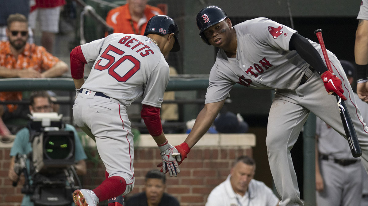 Boston Red Sox right fielder Mookie Betts (50) celebrates with third baseman Rafael Devers (11) after hitting a two run home run against the Baltimore Orioles at Oriole Park at Camden Yards.