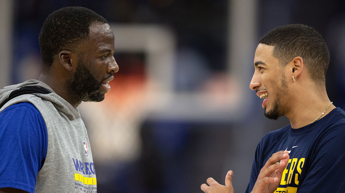 Golden State Warriors forward Draymond Green (23) and Indiana Pacers guard Tyrese Haliburton (0) chat before a game at Chase Center.