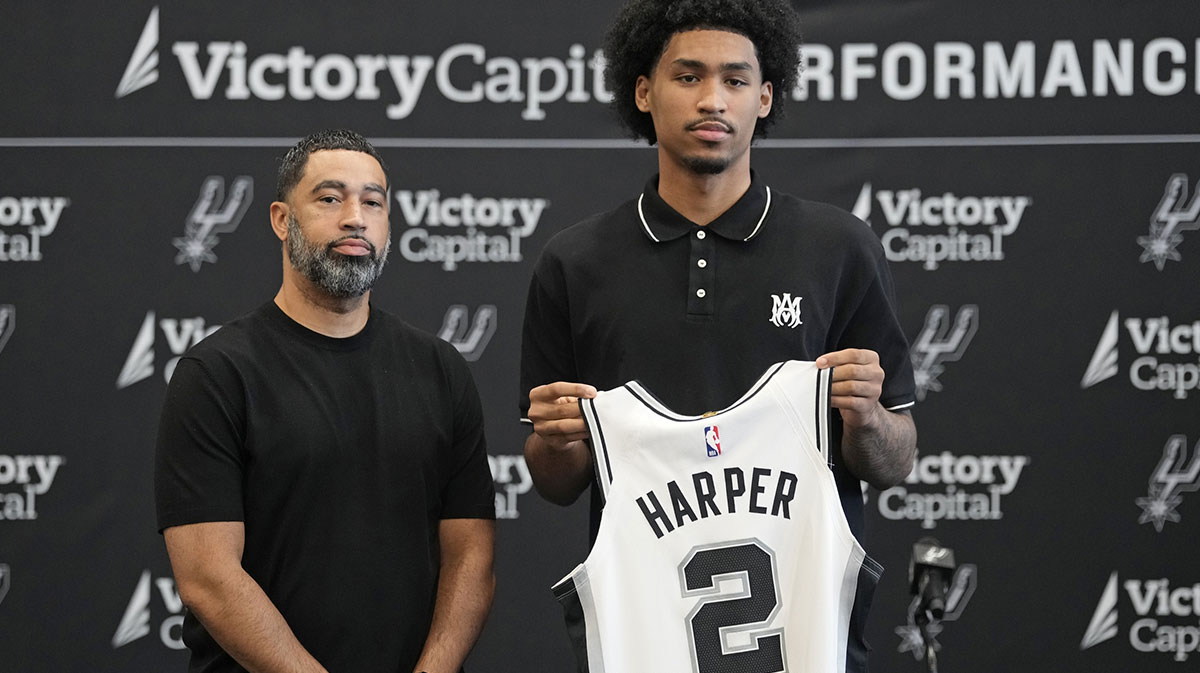 San Antonio first round draft pick Dylan Harper (2) holds up his jersey along with general manager Brian Wright at Victory Capital Performance Center.