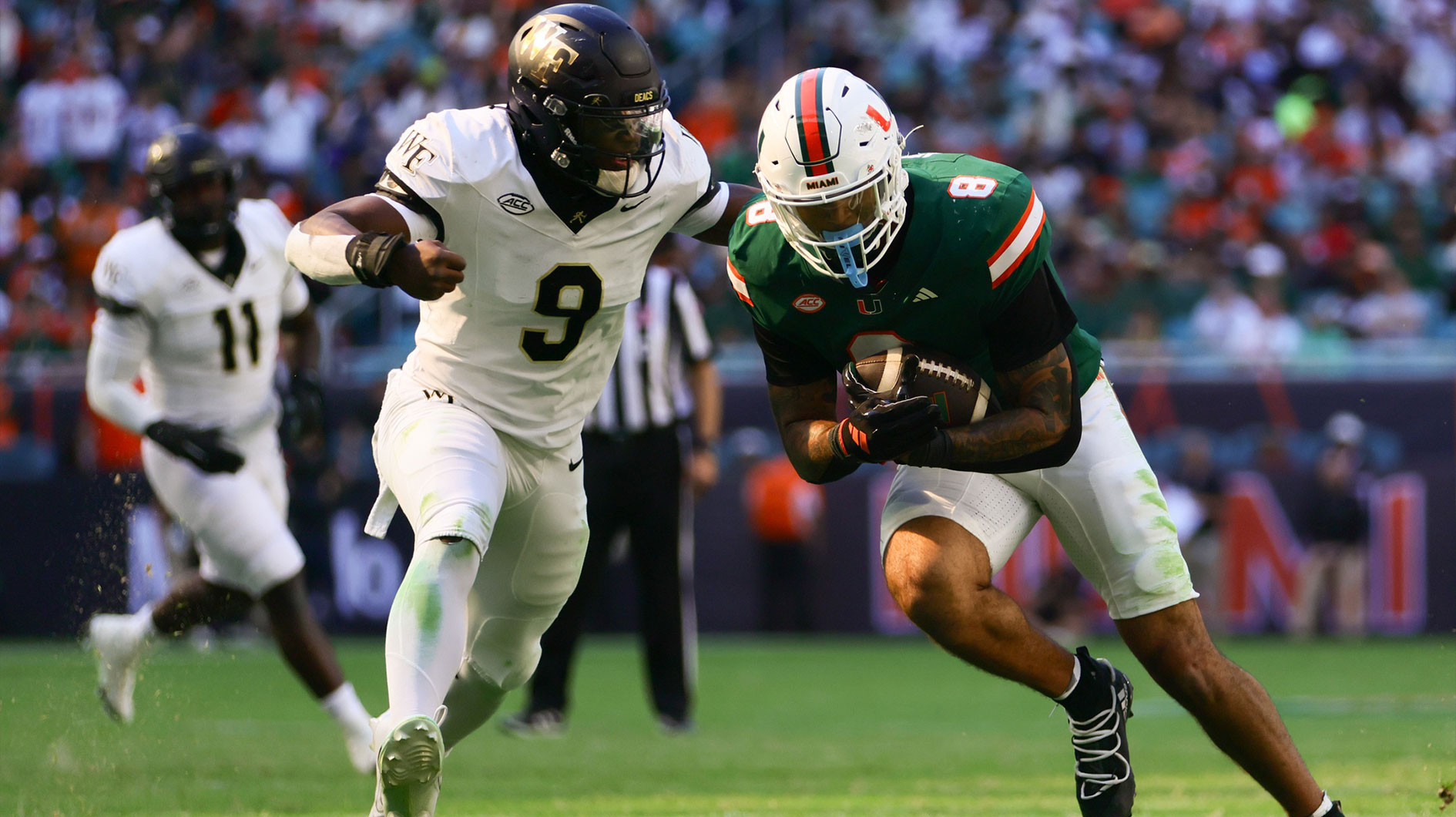 Miami Hurricanes tight end Elijah Arroyo (8) runs with the football as Wake Forest Demon Deacons linebacker Quincy Bryant (9) attempts a tackle during the second quarter at Hard Rock Stadium.