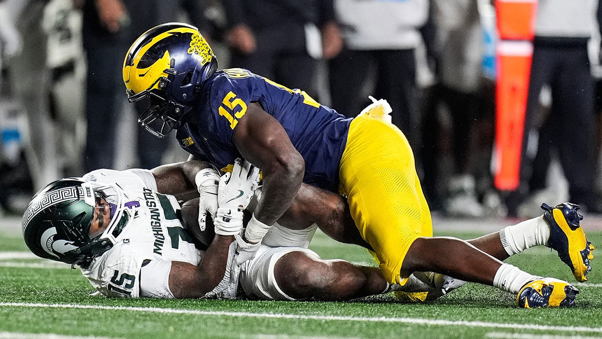 Michigan linebacker Ernest Hausmann (15) tackles Michigan State running back Kay'Ron Lynch-Adams (15) during the first half at Michigan Stadium