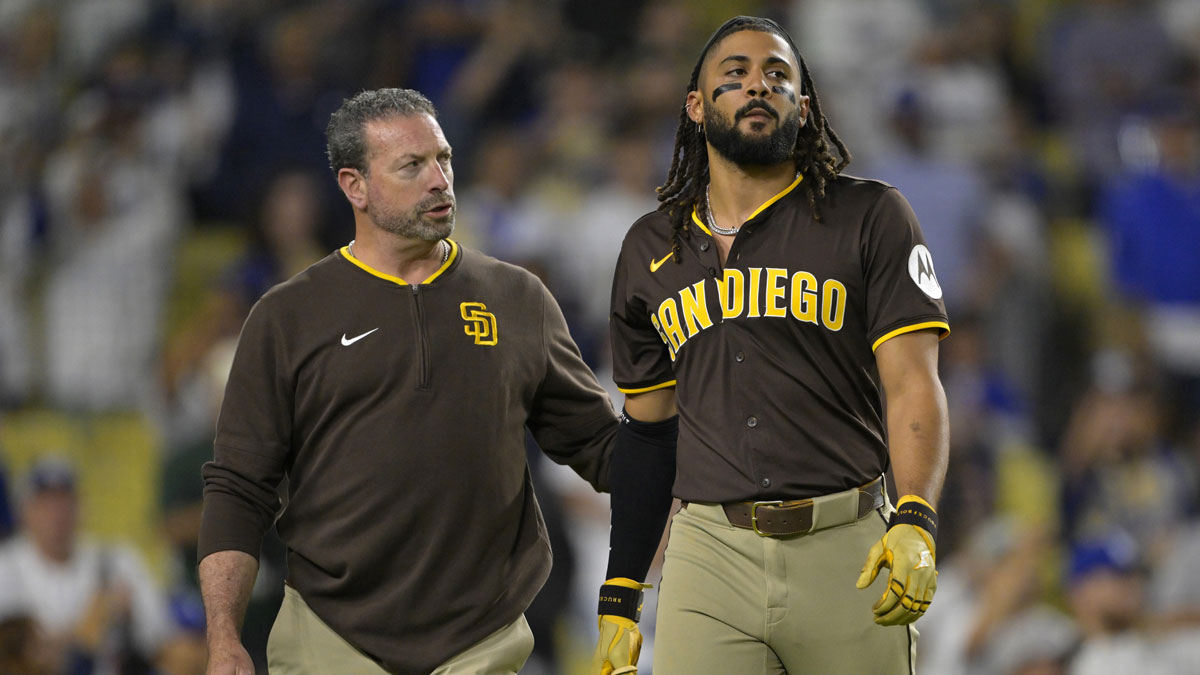 San Diego Padres head athletic trainer Mark Rogow walks with right fielder Fernando Tatis Jr. (23) off the field after he was hit by a pitch in the eighth inning against the Los Angeles Dodgers at Dodger Stadium.
