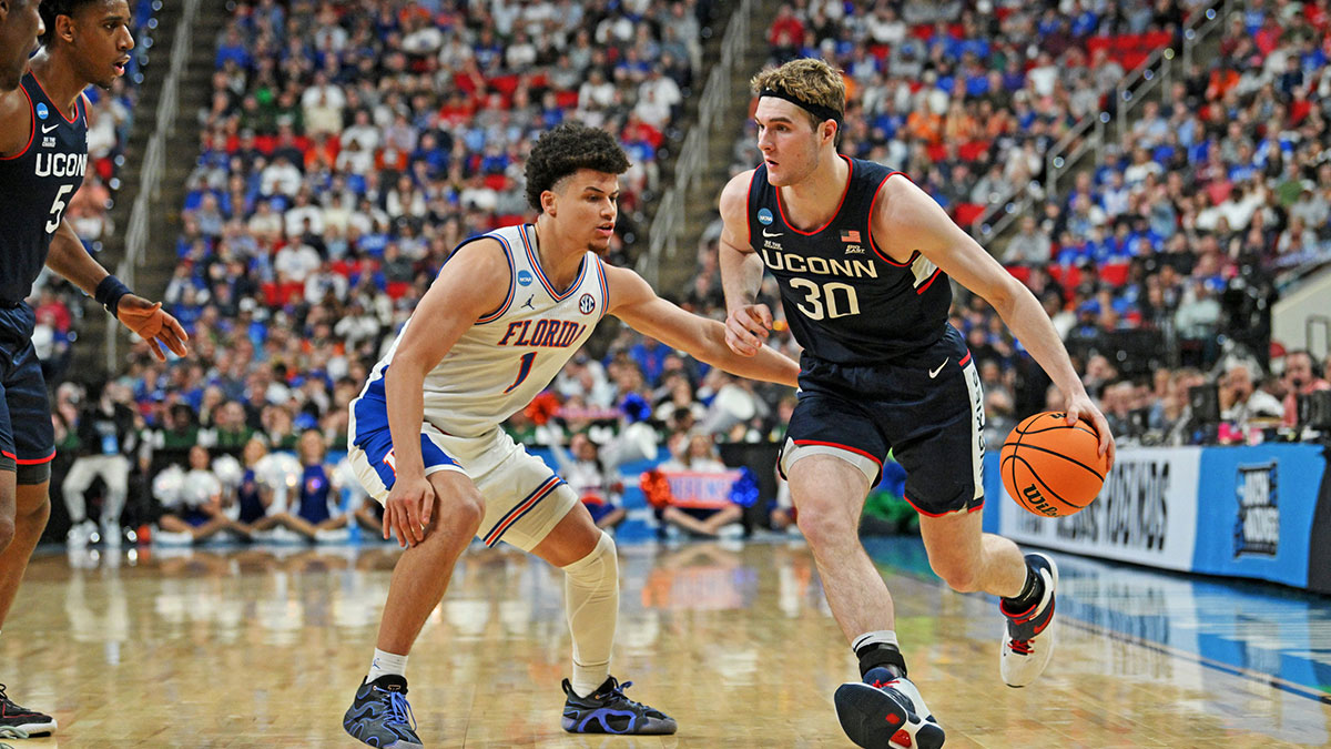 Connecticut Huskies forward Liam McNeeley (30) drives to the basket during the second half against Florida Gators guard Walter Clayton Jr. (1) in the second round of the NCAA Tournament at Lenovo Center.