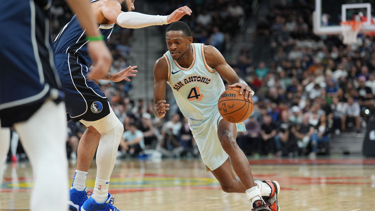 San Antonio Spurs guard De'Aaron Fox (4) dribbles against Dallas Mavericks forward Caleb Martin (16) in the first half at Frost Bank Center.