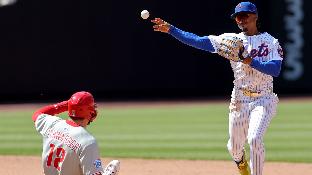 New York Mets shortstop Francisco Lindor (12) forces out Philadelphia Phillies designated hitter Kyle Schwarber (12) at second base and throws to first to complete a double play on a ball hit by Phillies catcher J.T. Realmuto (not pictured) during the fifth inning at Citi Field.
