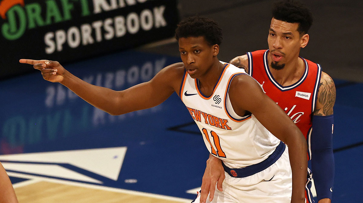Frank Ntilikina #11 of the New York Knicks directs his teammate as Danny Green #14 of the Philadelphia 76ers defends at Madison Square Garden on March 21, 2021 in New York City.