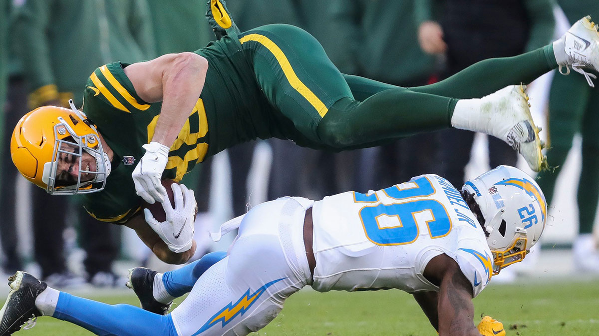 Green Bay Packers tight end Luke Musgrave (88) is upended by Los Angeles Chargers cornerback Asante Samuel Jr. (26) on Sunday, November 19, 2023, at Lambeau Field in Green Bay, Wis. The Packers won the game, 23-20.