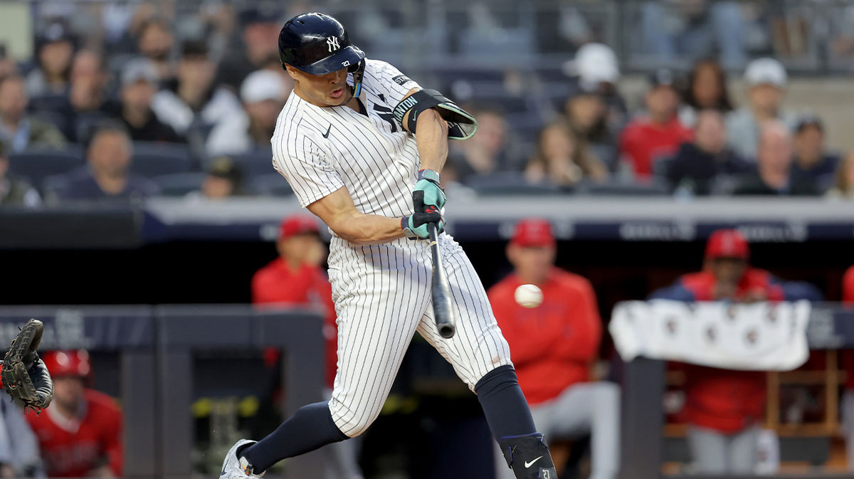 Jun 16, 2025; Bronx, New York, USA; New York Yankees designated hitter Giancarlo Stanton (27) hits a single against the Los Angeles Angels during the fourth inning at Yankee Stadium. Mandatory Credit: Brad Penner-Imagn Images