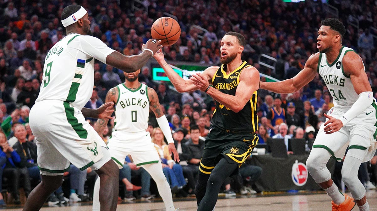 Golden State Warriors guard Stephen Curry (30) passes the ball between Milwaukee Bucks forward Bobby Portis (9) and forward Giannis Antetokounmpo (34) in the third quarter at the Chase Center.