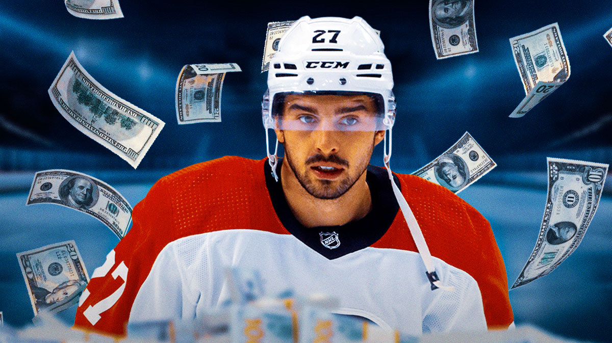 Noah Cates in image looking happy, some money in image, hockey rink in background