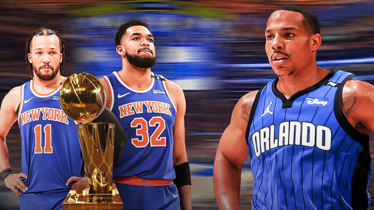 Desmond Bane in Magic jersey looking down at Jalen Brunson and Karl-Anthony Towns with the Larry Obrien trophy