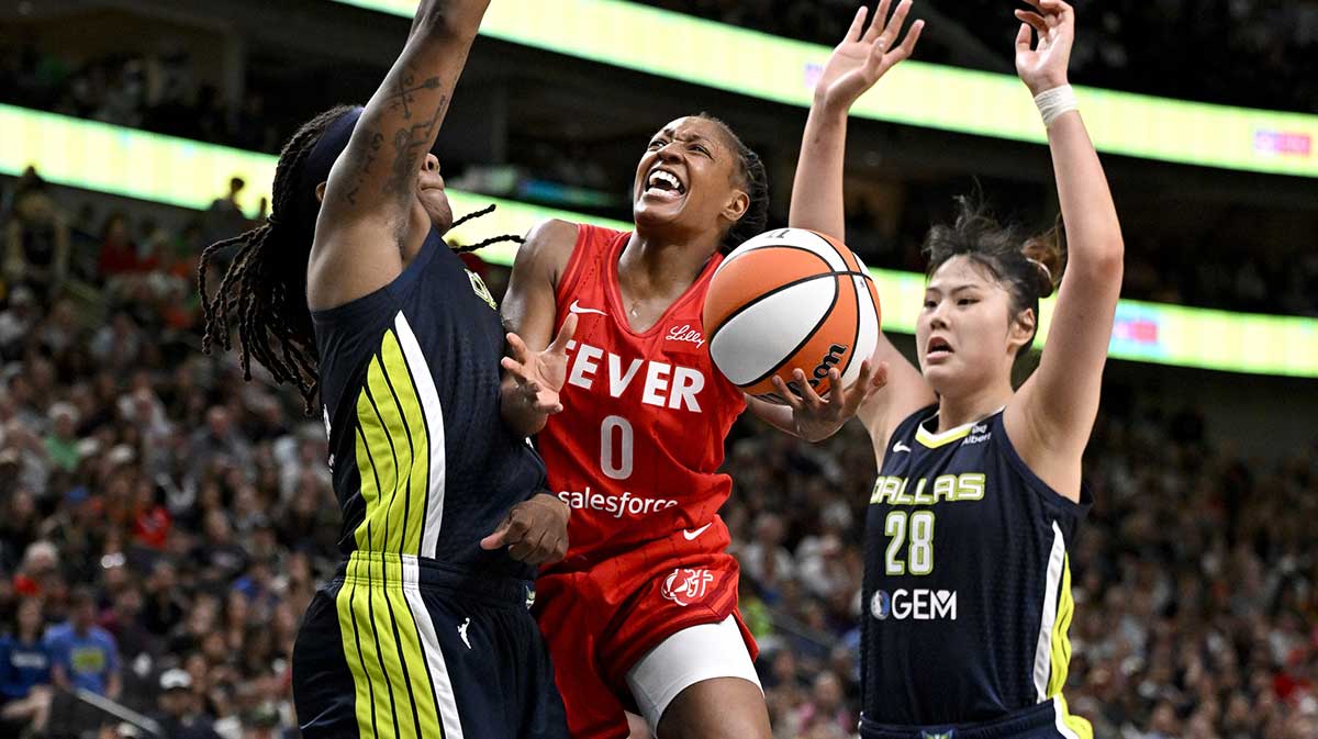 Indiana Fever guard Kelsey Mitchell (0) drives to the basket between Dallas Wings forward Myisha Hines-Allen (2) and center Li Yueru (28) during the second half at the American Airlines Center.