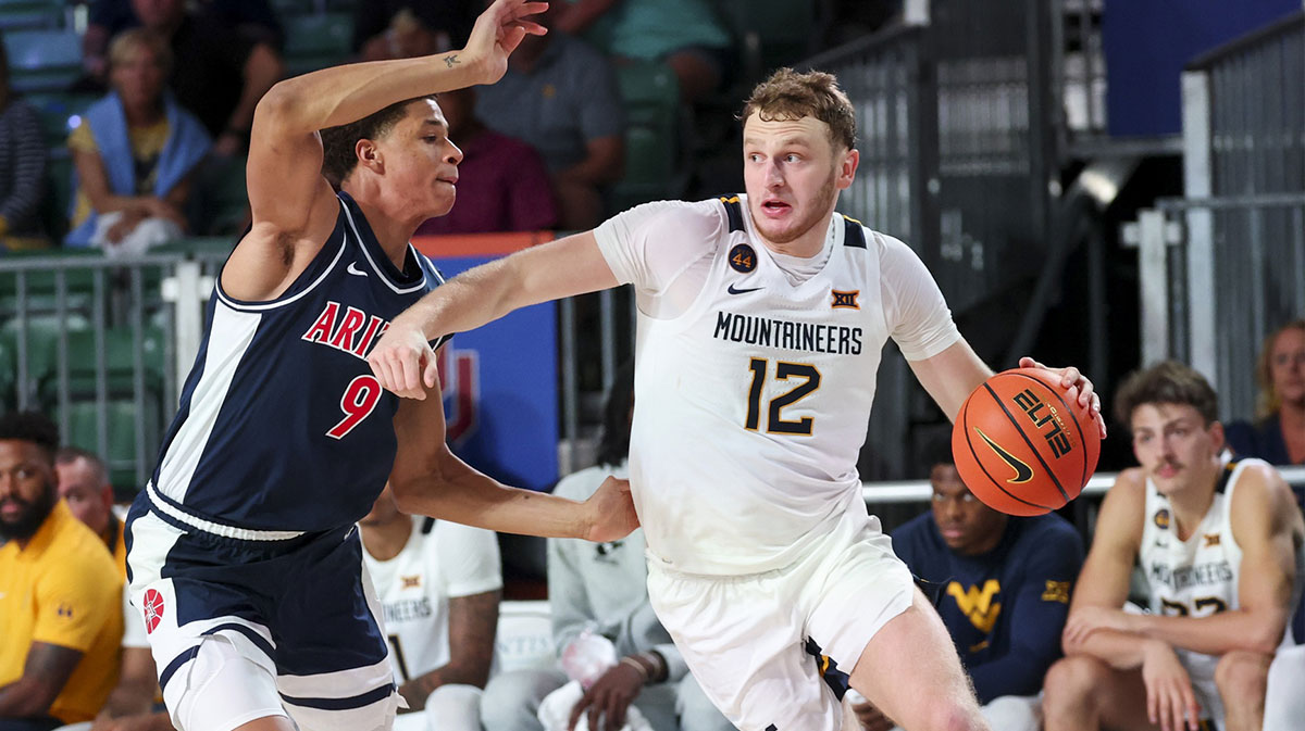 West Virginia Mountaineers guard and Indiana basketball transfer Tucker DeVries (12) drives to the basket as Arizona Wildcats forward Carter Bryant (9) defends during the second half at Imperial Arena at the Atlantis resort.